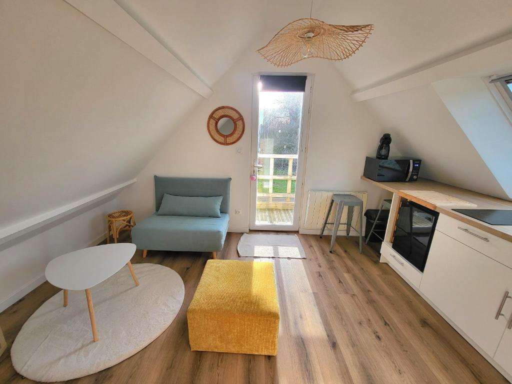 a small living room with a table and a chair at L'escapade ansérienne in Oye-Plage