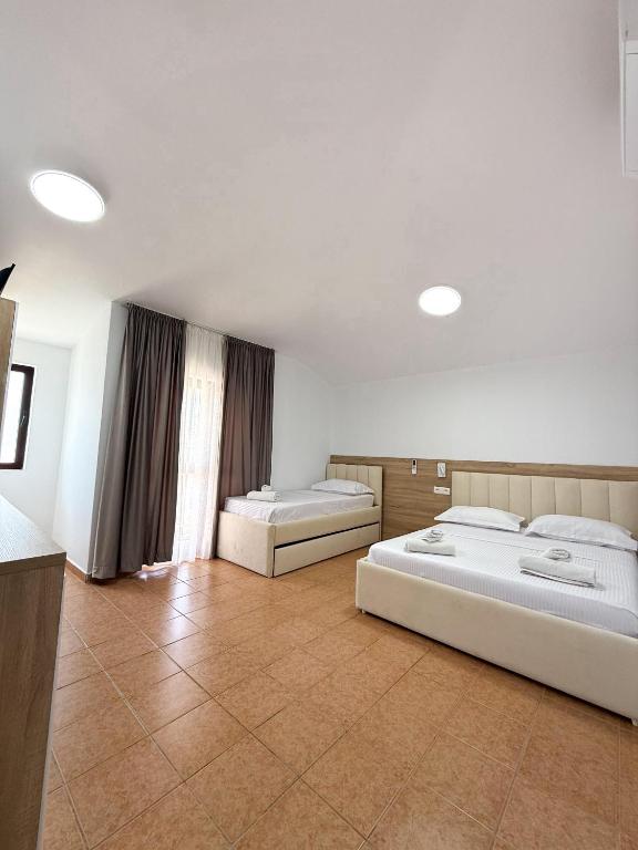 a large room with two beds in it at Hotel Margjokaj2 Velipoje in Velipojë
