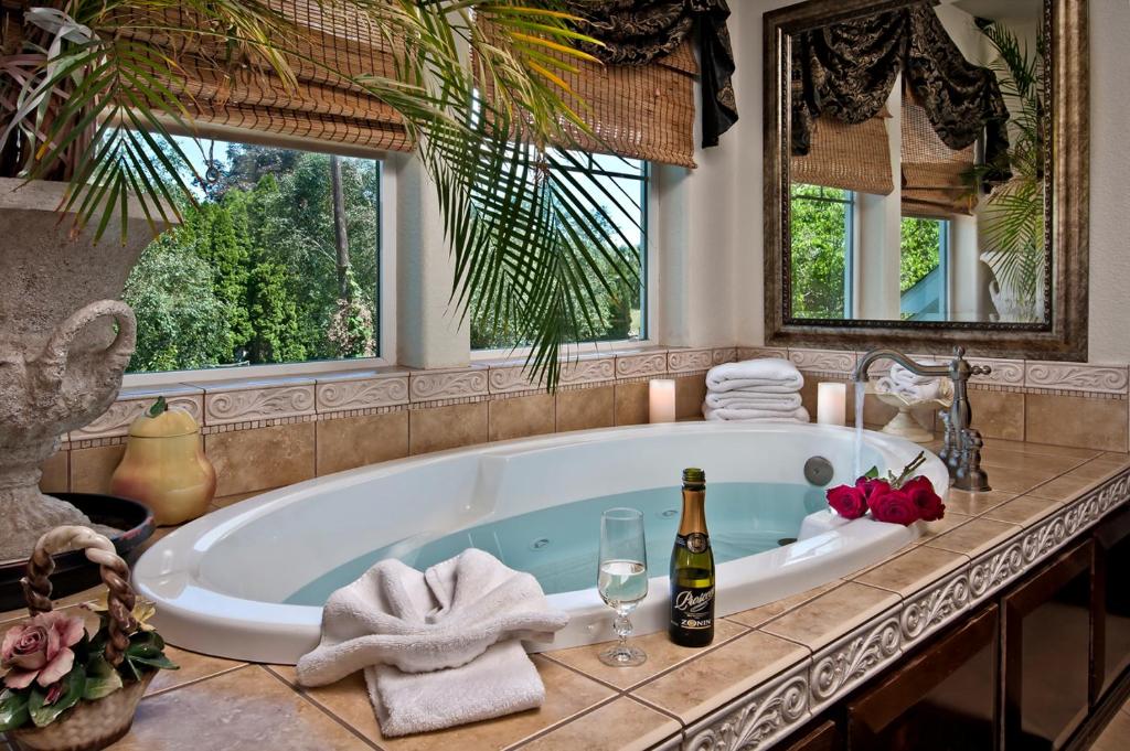 a bathroom with a bath tub with two windows at Cozy Rose Inn in Prosser