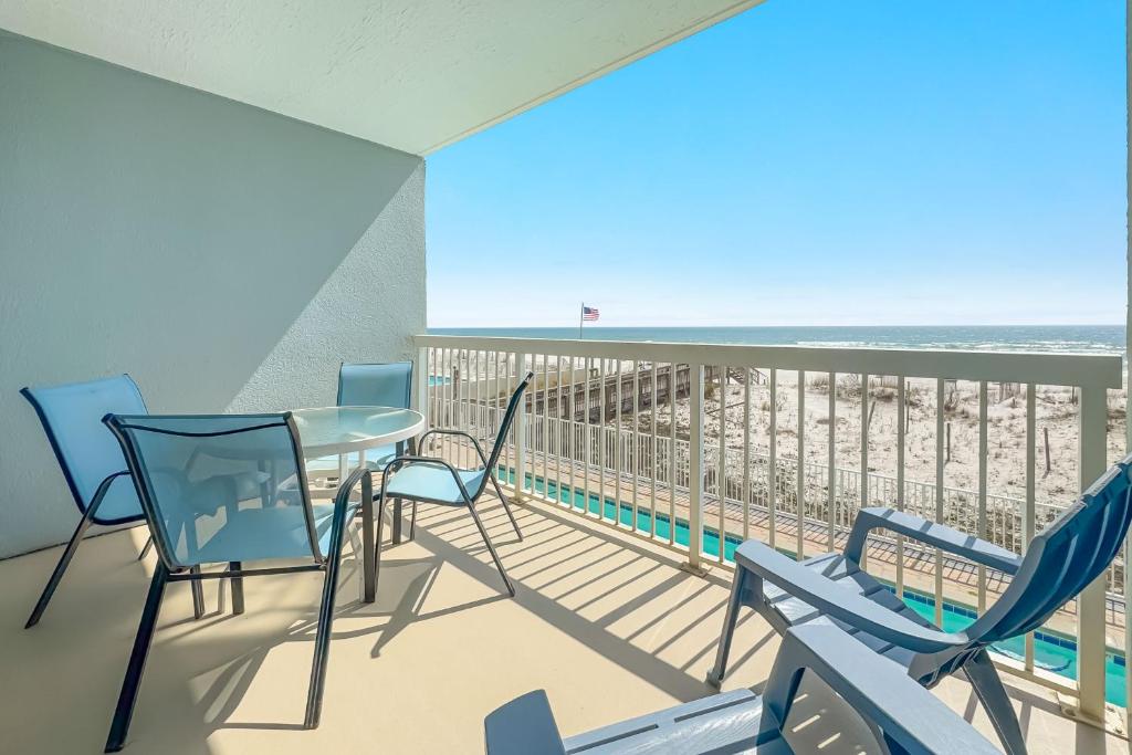 a balcony with a table and chairs and the beach at Caribbean Unit 103 in Gulf Shores
