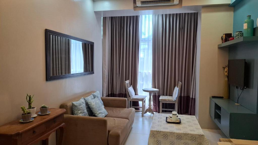 a living room with a couch and a tv at Maison Brise Condominium Unit Pico De Loro Nasugbu in Nasugbu