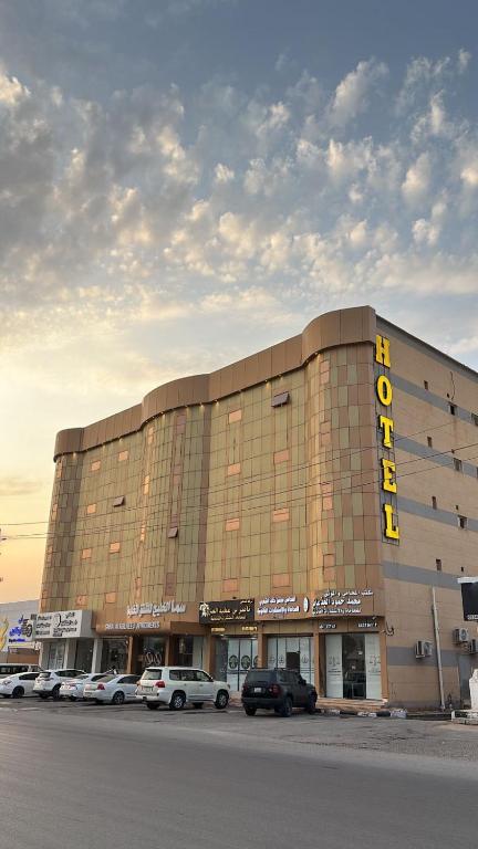 a large building with cars parked in front of it at سما الخليج للشقق المخدومة in Hafr Al-Batin