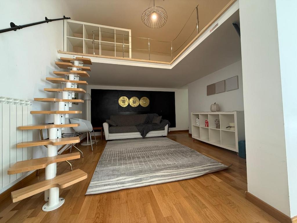 a living room with a spiral staircase and a couch at I Maltesi apartment in Sassari