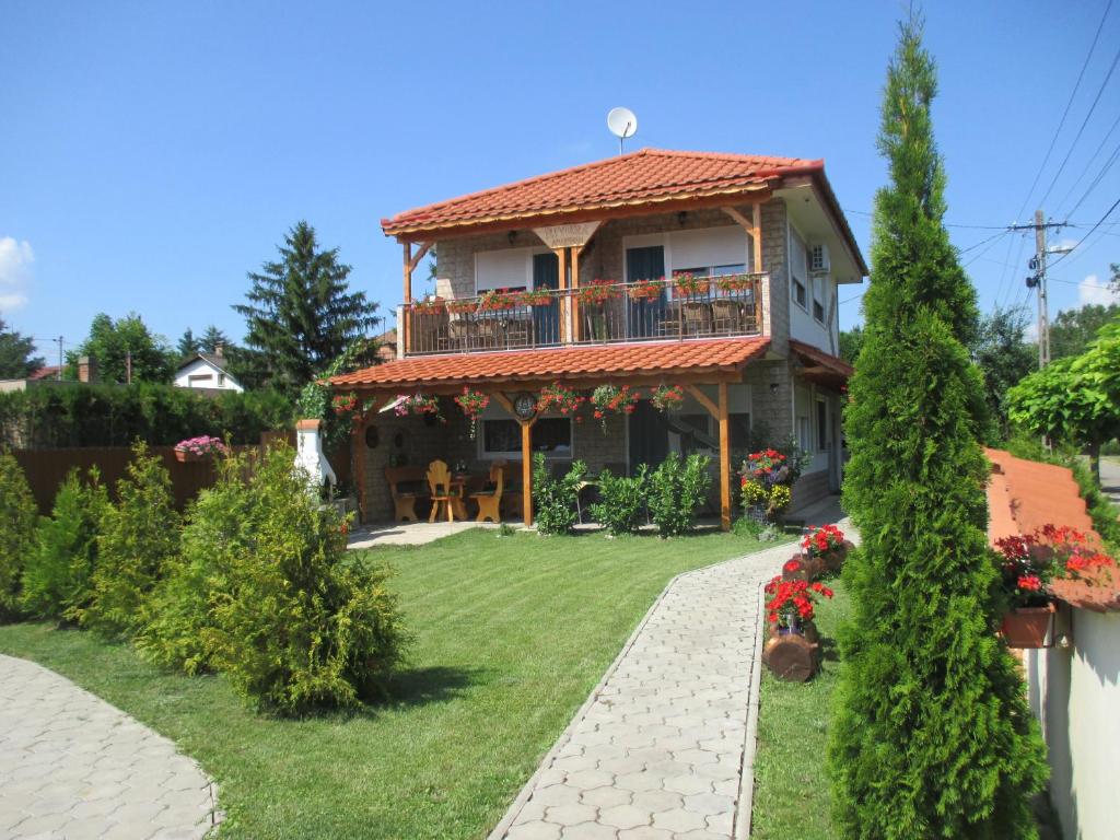 a house with a balcony and a yard at Riviera Apartman in Hajdúszoboszló