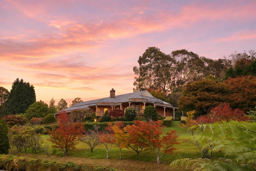 a house in the middle of a field with trees at Tiverton in Kurrajong