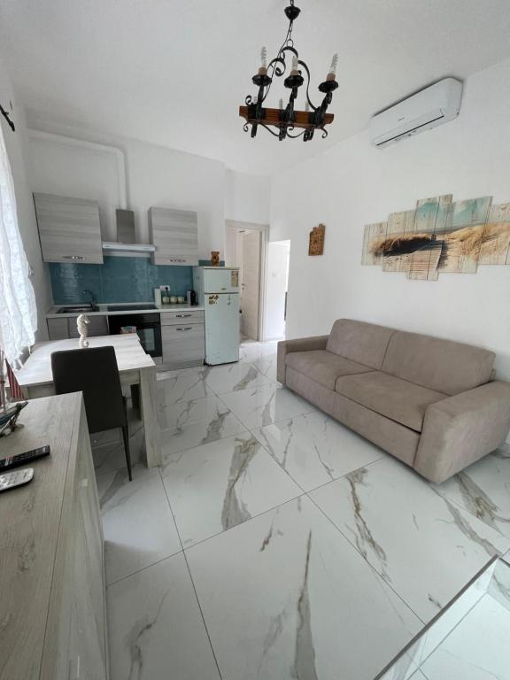 a living room with a couch and a kitchen at Apartment with garden PERLA NERONIANA in Anzio
