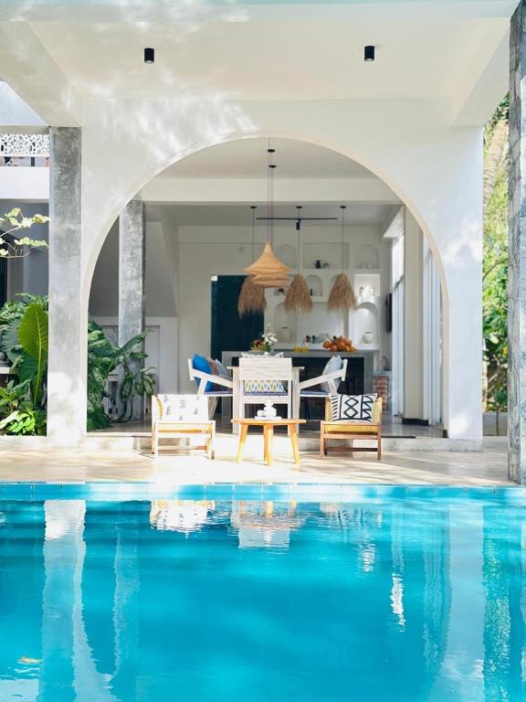 a villa with a swimming pool next to a house at Celestine's Hideaway in Kamburugamuwa