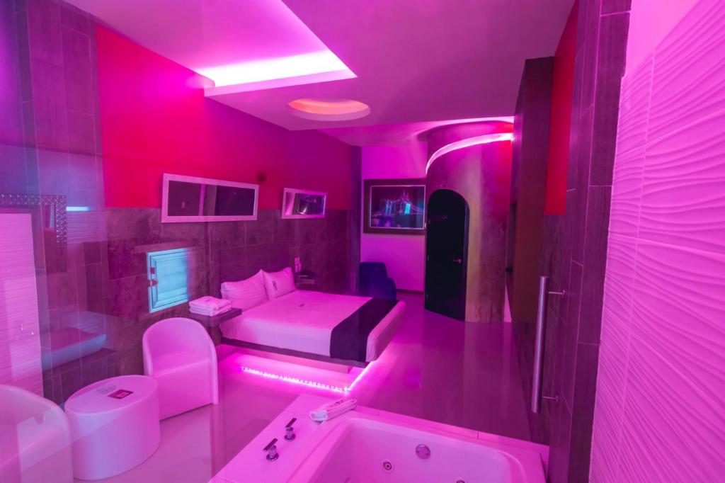 a pink bathroom with a tub and a sink at COSMOPOLITAN Autohotel in Boca del Río