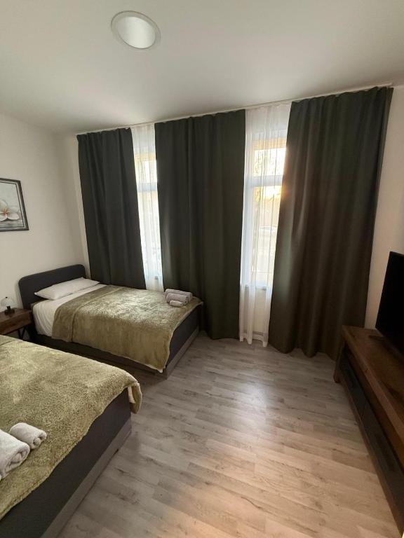 a bedroom with two beds and a window with curtains at Andoniev in Salzelmen