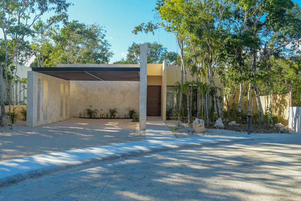 a building with a garage with trees in front of it at Casa Edén in Xpu Ha