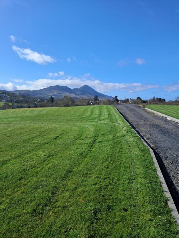 a field of green grass next to a road at Reek View Accommodation in Westport