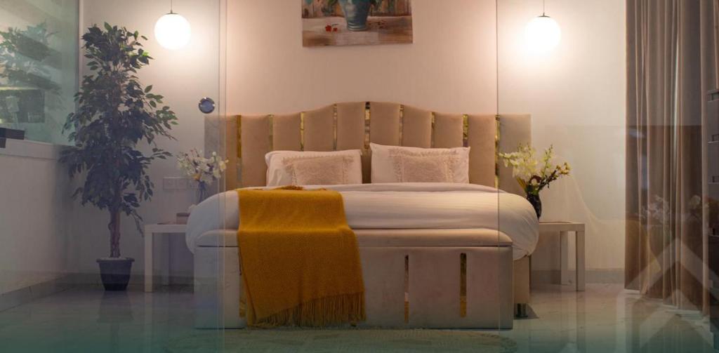 a bedroom with a bed with a yellow blanket on it at شاليه روجا Roja Chalet in As Sulayf