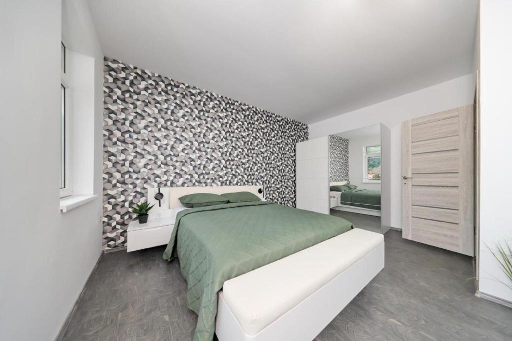 a white bedroom with a bed and a wall at Residence Deluxe Benamino in Bran