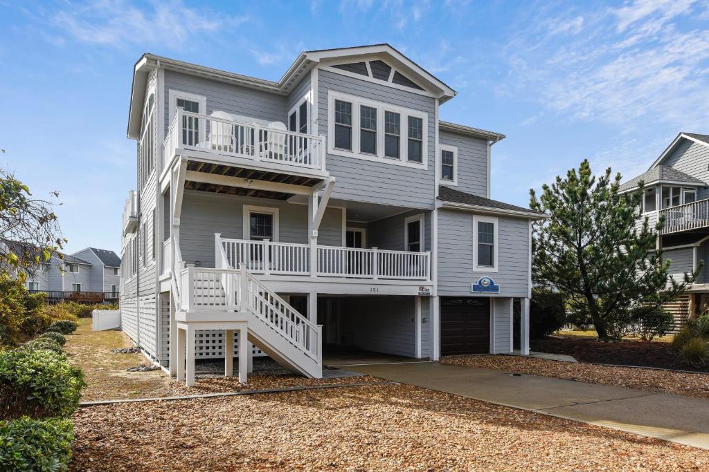 a white house with a porch and a balcony at 4108 - New Beginnings in Duck