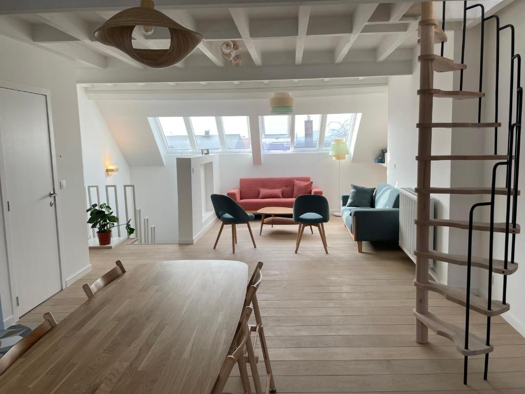 a living room with a red couch and a spiral staircase at Triplex de charme avec vue in Brussels