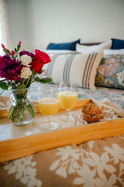a tray with two glasses of orange juice and a vase of flowers at The Old Crowe Inn Bed and Breakfast in Fruita