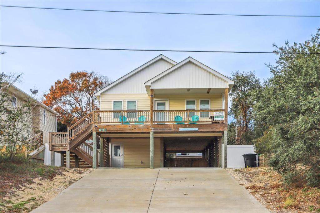 a house with a deck and a balcony at 5176 - Sandy Bottoms in Kill Devil Hills