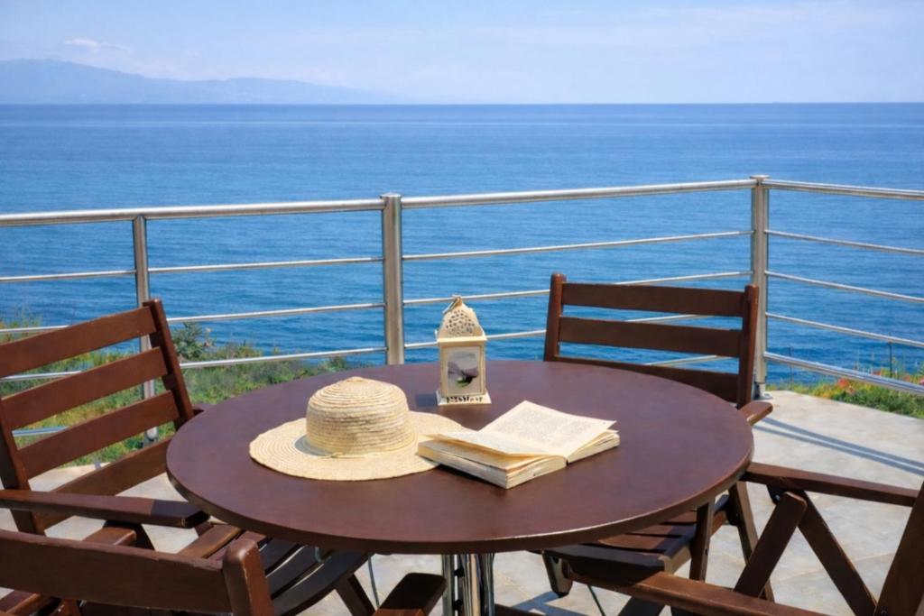 a hat and book on a table on a balcony at Panorama Beach in Chrani