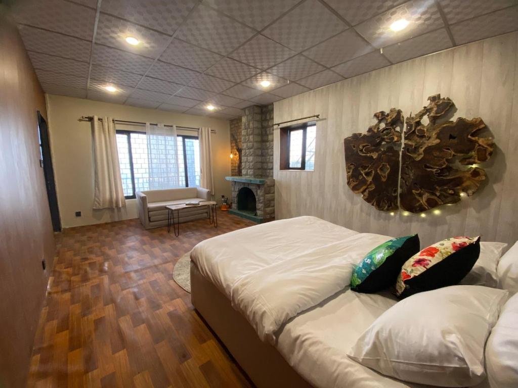 a bedroom with a large bed and a living room at Acacia Homes in Kuldanna
