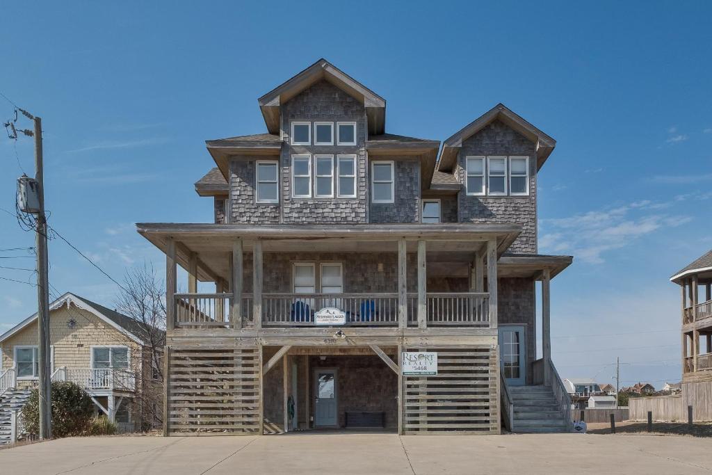 a large wooden house with a balcony at 5468 - Mermaids' Lagoon in Nags Head