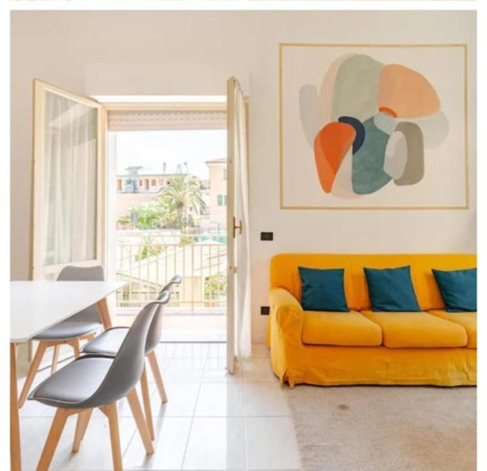 a living room with a yellow couch and a table at Colibrì in Bordighera