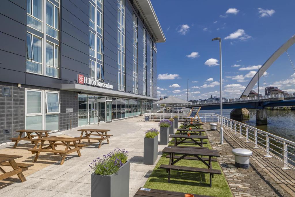 a row of picnic tables in front of a building at Hilton Garden Inn Glasgow City Centre in Glasgow