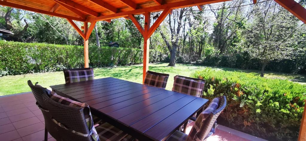 a wooden table and chairs on a patio at HauSol Vendégház in Gárdony