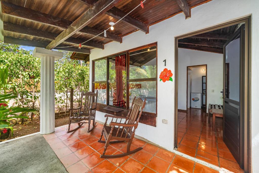 a patio with two rocking chairs on a house at Hotel Hibiscus in Playa Junquillal
