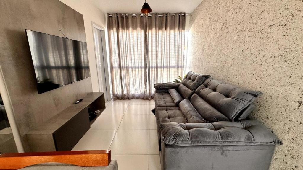 a living room with a leather couch and a television at Dona Olivia Universidade 17 in Vitória da Conquista