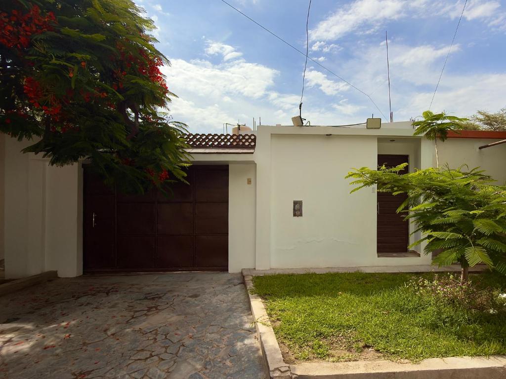 a white house with a garage and a driveway at Huacachina Desert II in Ica