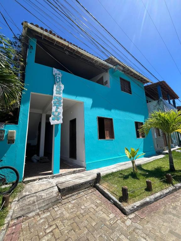 a blue house with a pole in front of it at Pousada Nativa - Vista ao mar in Ilha de Boipeba
