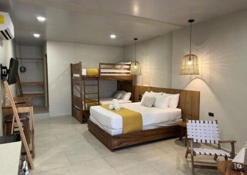 a bedroom with a bed and bunk beds in it at Litos Hotel y Restaurante in Playa San Blas