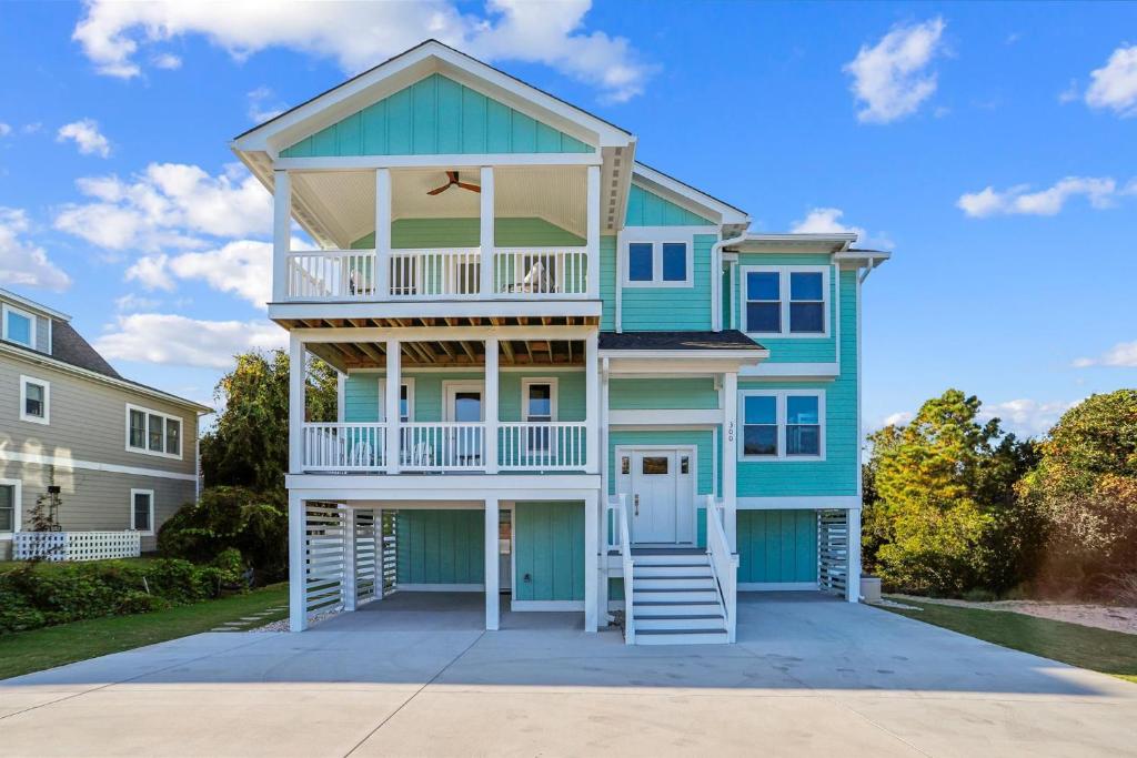 a blue house with a balcony on a driveway at 4920 - Stress Less II in Kitty Hawk