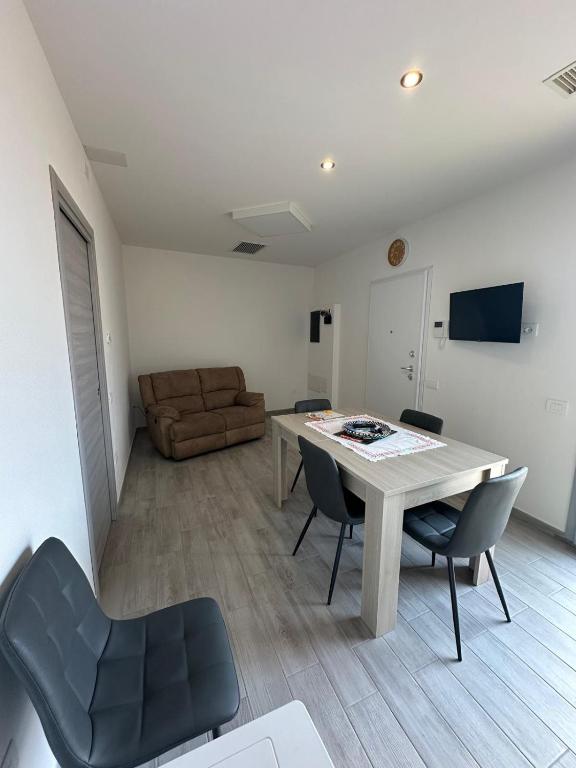 a living room with a table and chairs and a couch at Alba&Tramonto in Arbus