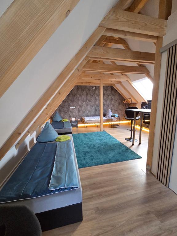 a room with an attic with a couch and a piano at Moderne Dachgeschosswohnung am Wald in Großnaundorf
