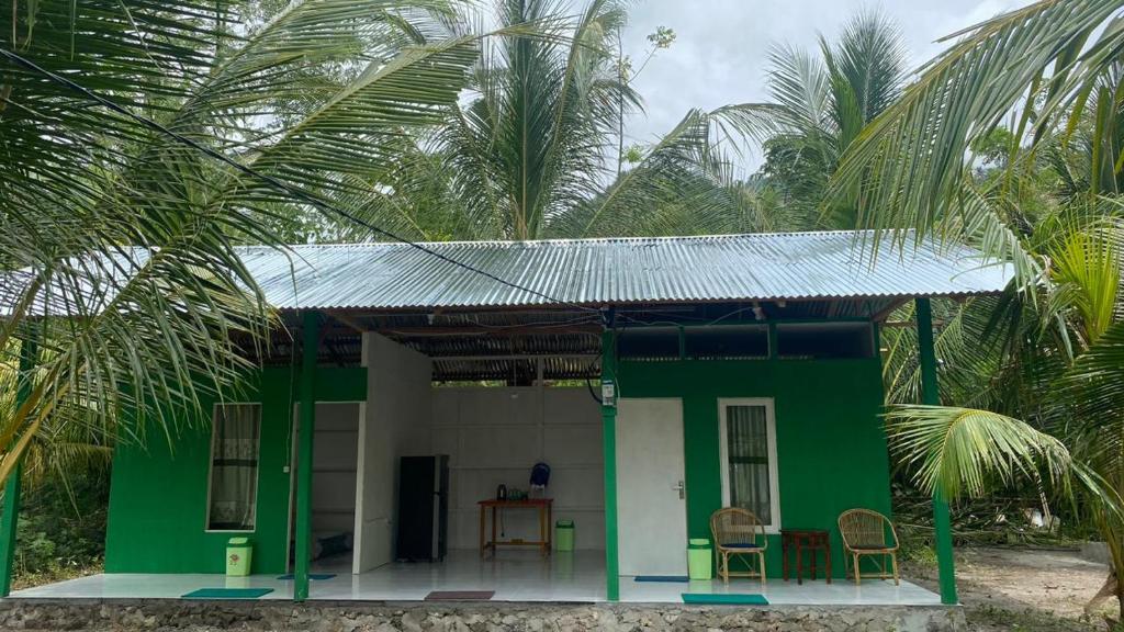 a green and white house with a table and chairs at The Green Pearl Paradise in Biluhu
