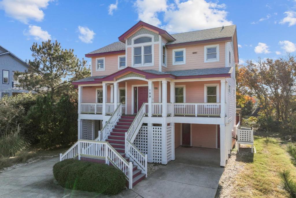 a pink house with white railings at 3947 - Leg-O Duck in Duck