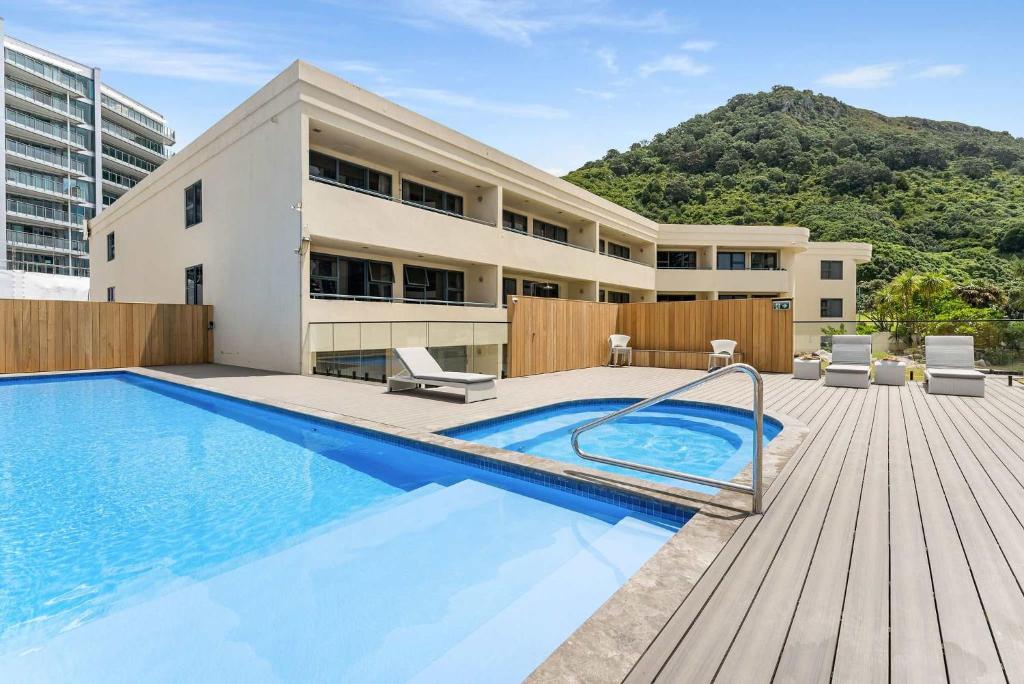 a swimming pool in front of a building at Ocean Seascape - Mt Maunganui in Mount Maunganui