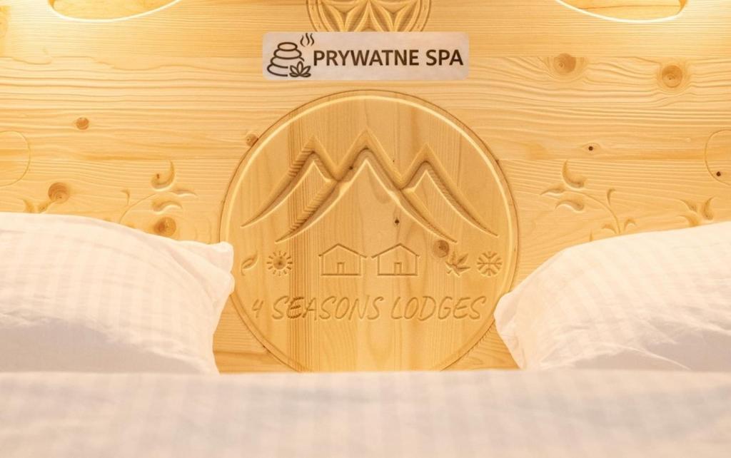 a olympics medal on a wooden wall with a bed at Domek A - domki w górach z prywatnym SPA - 4 seasons lodges Ustroń in Ustroń