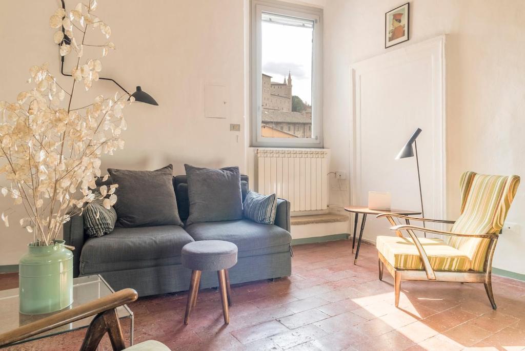 a living room with a blue couch and chairs at Loft with a ducal view in Urbino