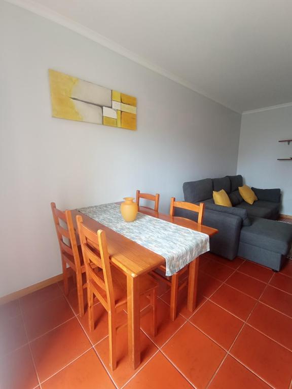 a dining room with a table and chairs and a couch at Village Sea House - Porto Moniz in Porto Moniz