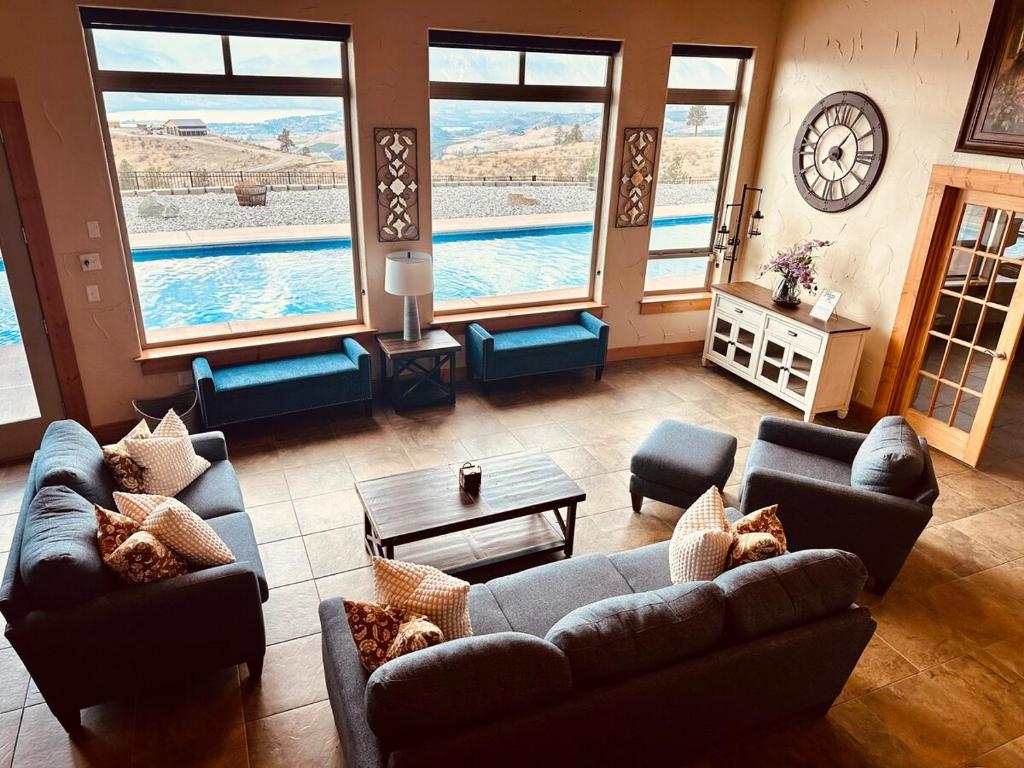 a living room with couches and a view of a pool at Alpine Luxury Chelan Vacation Rentals in Chelan