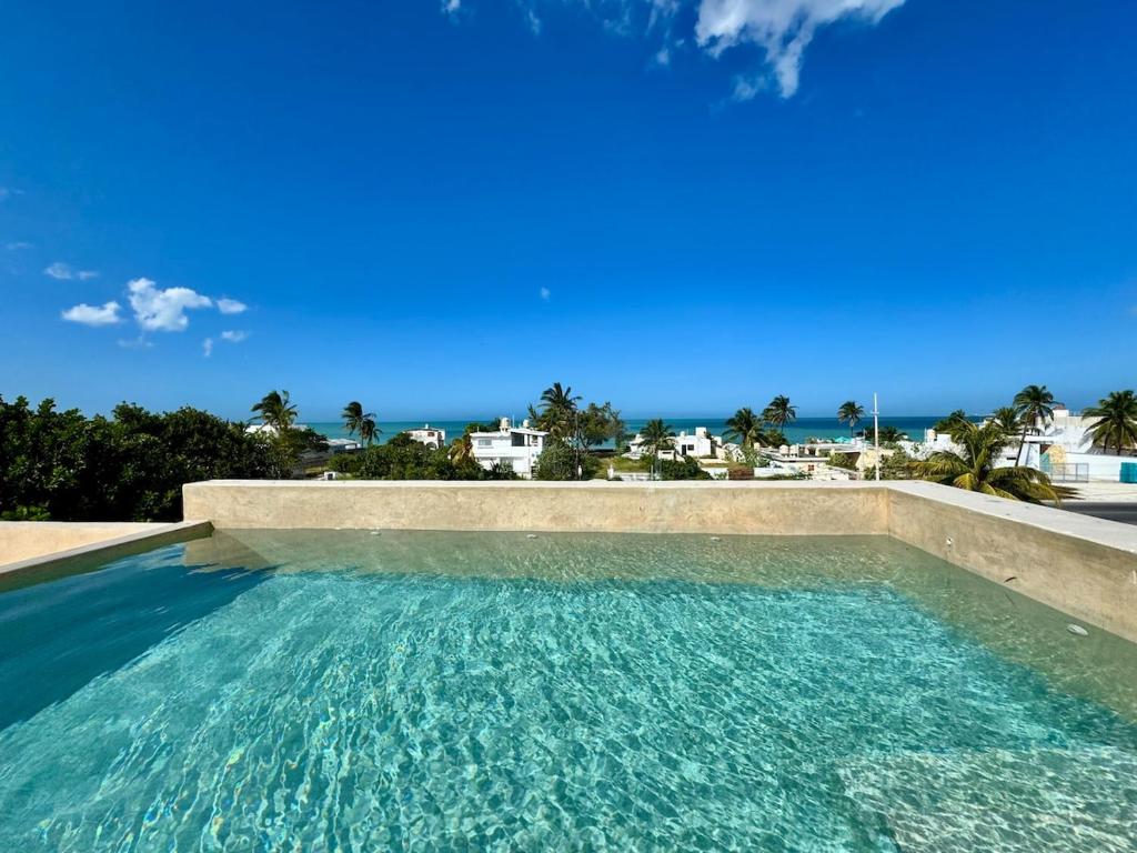 a swimming pool with a view of the ocean at Panoramic Ocean Views - Villa Home Chelem in Chelem