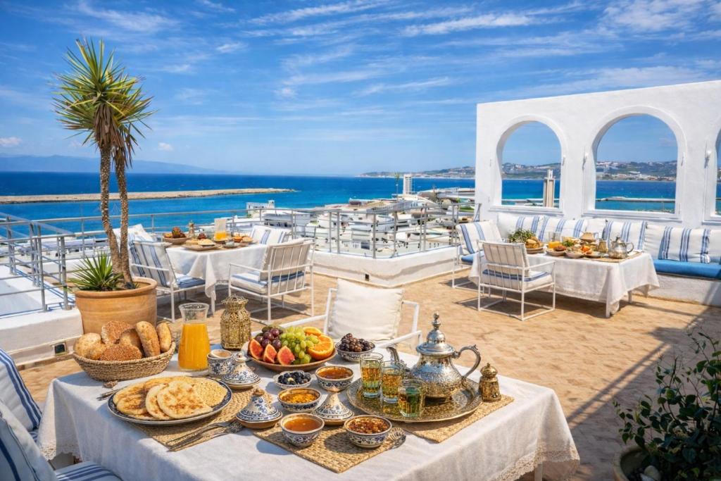 a table with food on a balcony with the ocean at Le balcon de tanger in Tangier
