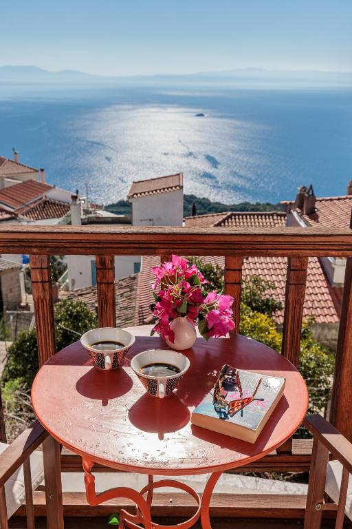 a table on a balcony with a view of the ocean at Christys House Skopelos in Glossa