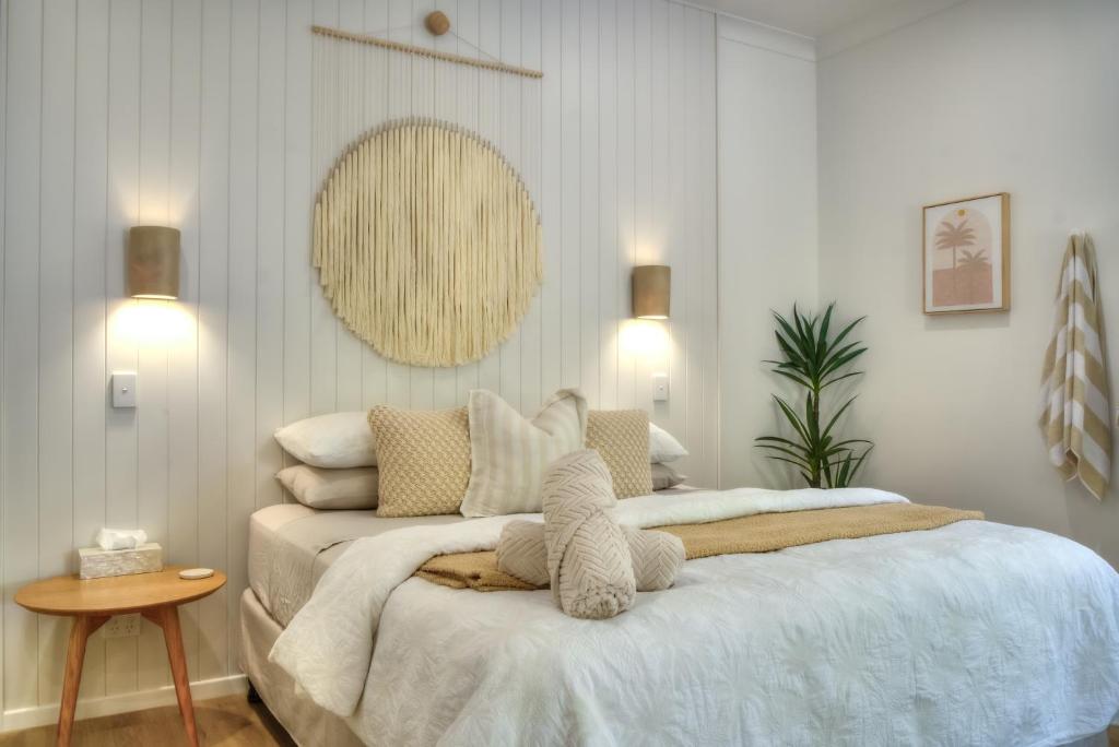a bedroom with a bed with white sheets and pillows at Solis in Agnes Water in Agnes Water