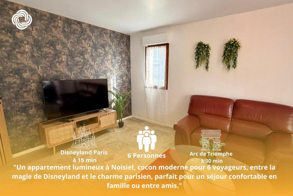 a living room with a couch and a television at Le Terrier in Noisiel