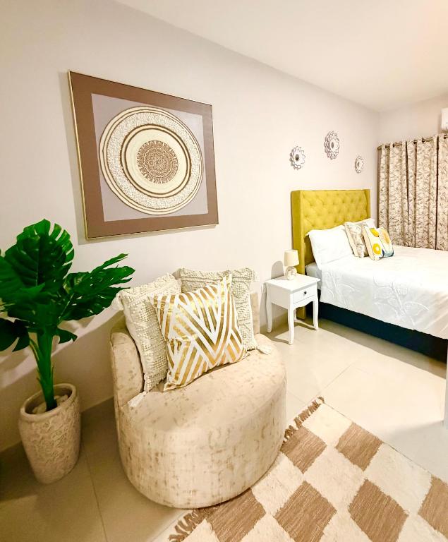 a living room with a chair and a bed at Orchid Belvedere Suites 102 - The Fig in Gaborone