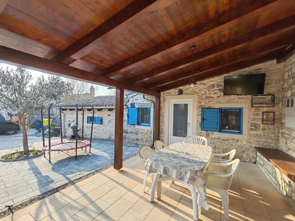 eine Terrasse mit Tisch, Stühlen und Fernseher in der Unterkunft ManuIris in Butkovići