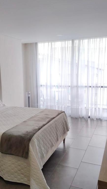 a bedroom with a large bed with white curtains at Estocolmo in Armenia